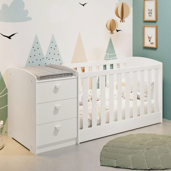 Multicuna Reddy blanca cuna con comoda con cajones y cambiador en la parte superior, en una habitación infantil decorada.